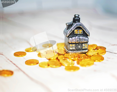 Image of The house stands on a pile of coins, the concept of cash savings