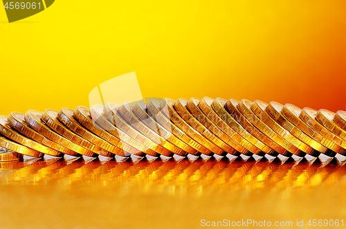 Image of Coins lying on the Golden surface with a Golden background