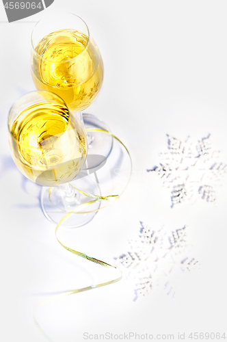 Image of Two glasses of wine and snowflakes on a white background. Holiday concept.