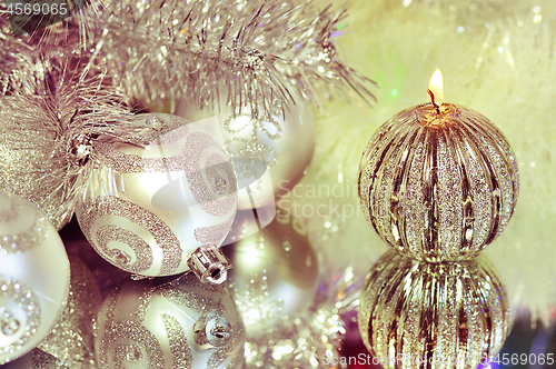 Image of Christmas decorations with candle and silver balls.