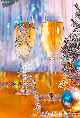 Image of Glasses with wine, tinsel, Christmas tree and toys