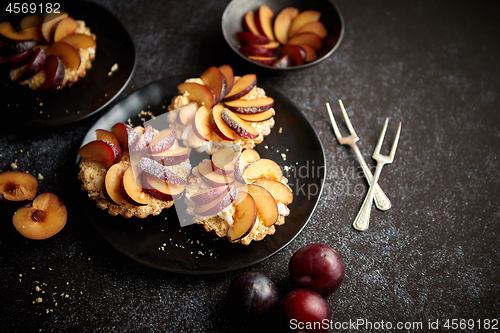 Image of Delicious homemade mini tarts with fresh sliced plum fruit