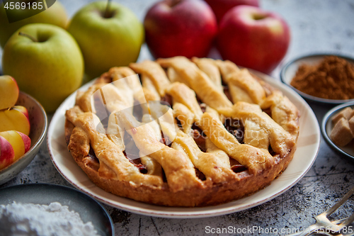 Image of Fresh baked tasty homemade apple pie cake with ingredients on side