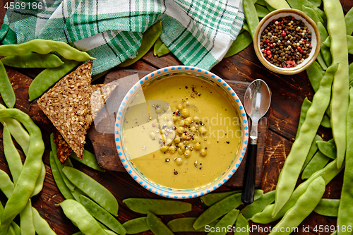 Image of Green pea cream soup in grey bowl