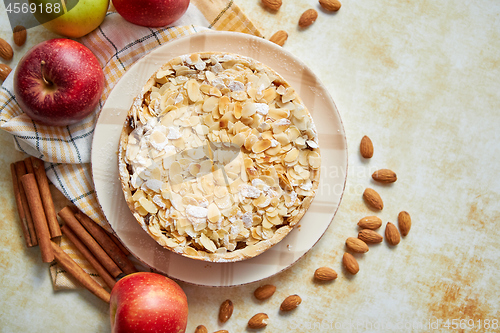 Image of Freshly baked homemade apple pie with almond flakes cake on yellow