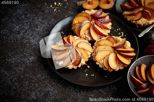 Image of Delicious homemade mini tarts with fresh sliced plum fruit