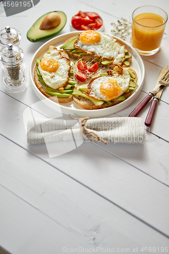 Image of Delicious healthy breakfast with sliced avocado sandwiches with fried egg