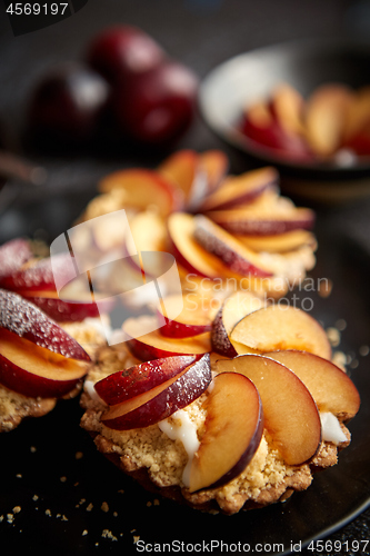 Image of Delicious homemade mini tarts with fresh sliced plum fruit