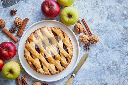 Image of Fresh baked tasty homemade apple pie cake with ingredients on side