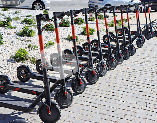 Image of Electric kick scooter parked on rental station