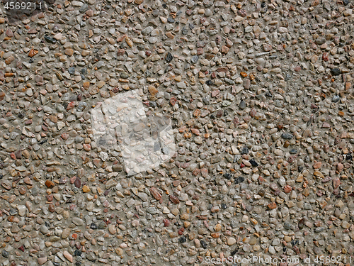 Image of Concrete wall with sandy shapeless stones inlaid into it