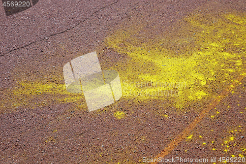 Image of Yellow spots on brown asphalt surface