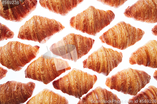 Image of Pattern from freshly baked croissants on a white background.