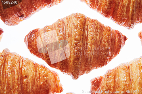 Image of Close up pattern fresh french croissants on a white background.