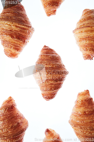 Image of Freshly baked homemade croissants on a white background.