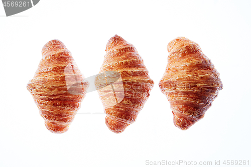 Image of Set of three homemade french croissants on a white background.