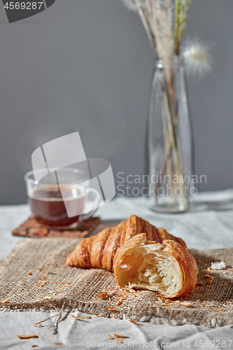 Image of Morning breakfast still life with fresh croissants and coffee cup on a gray.