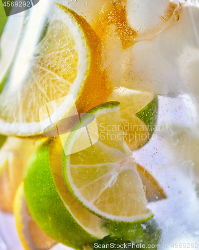 Image of Macro citrus drink background with lemon and lime slices in a glass.