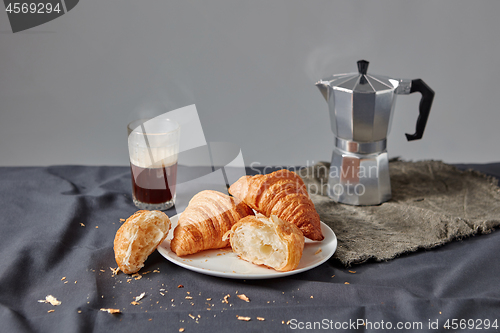 Image of Freshly baked croissants with coffee cup on a dark gray background.
