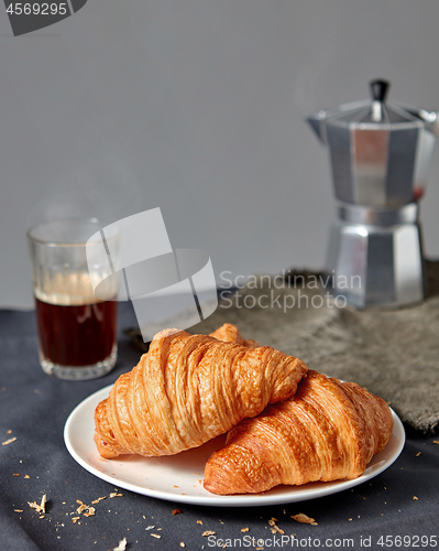 Image of Morning breakfast with croissant and coffee on a gray background.