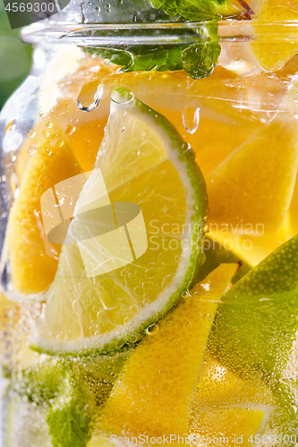 Image of Cold refreshing water with lime and lemon in a glass.