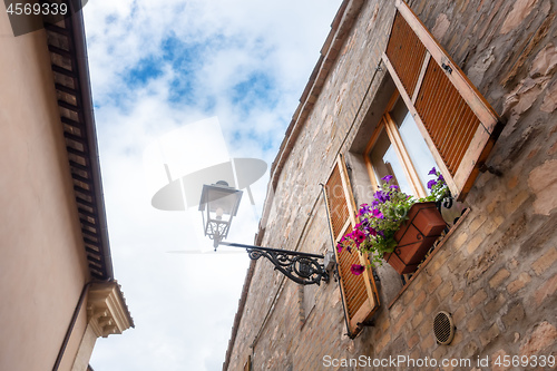 Image of house in Italy with petunia flowers on the window