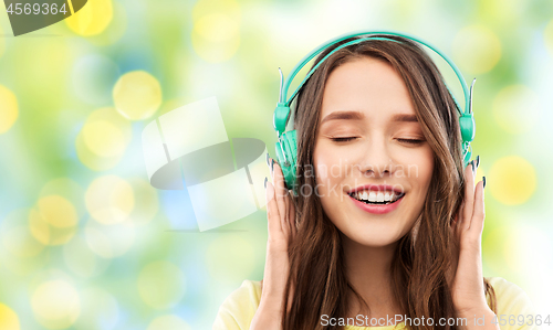 Image of happy young woman or teenage girl with headphones