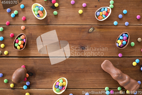 Image of chocolate eggs, easter bunny and candies on wood