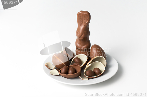 Image of chocolate bunny, eggs and candies on white plate