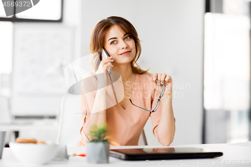 Image of businesswoman calling on smartphone at office