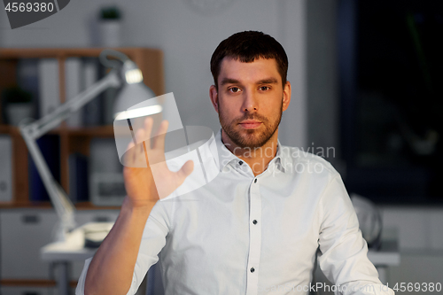 Image of businessman using gestures at night office