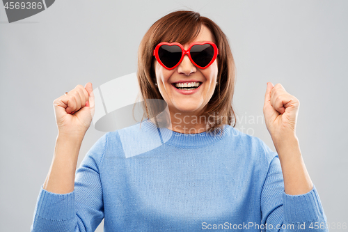 Image of smiling senior woman in heart-shaped sunglasses