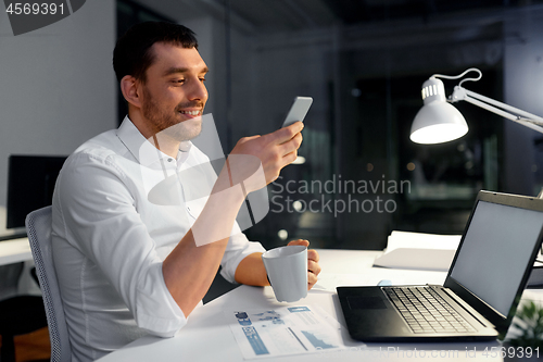 Image of businessman with smartphone and coffee at office