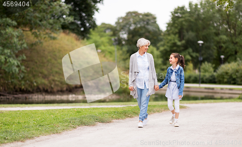 Image of grandmother and granddaughter walking at park