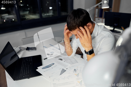 Image of businessman with papers working at night office