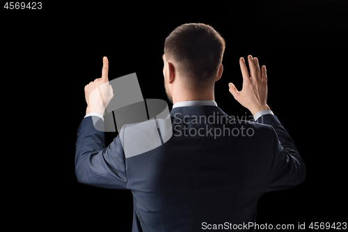 Image of businessman working with invisible virtual screen