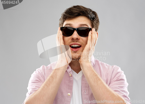 Image of amazed young man in black sunglasses