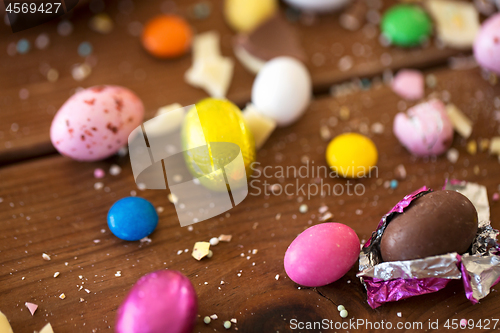 Image of chocolate eggs and candy drops on wooden table