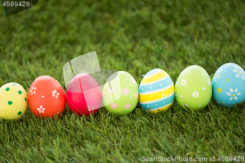 Image of row of colored easter eggs on artificial grass