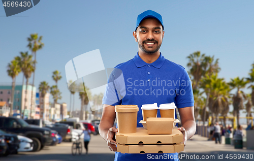 Image of happy indian delivery man with food and drinks