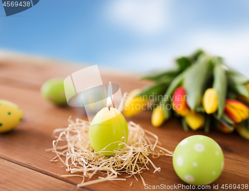 Image of candle in shape of easter eggs and tulip flowers