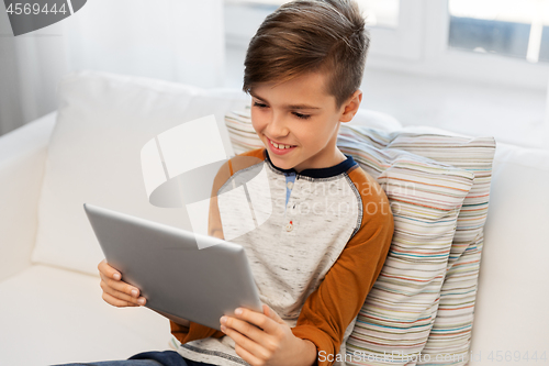 Image of smiling boy with tablet pc computer at home