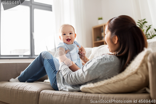 Image of happy mother with little baby son at home