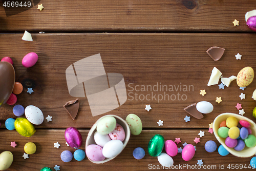 Image of chocolate eggs and candy drops on wooden table