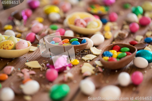 Image of chocolate eggs and candy drops on wooden table