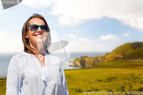 Image of smiling woman in sunglasses over big sur coast