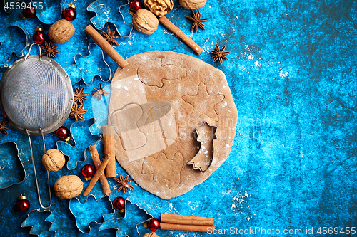 Image of Christmas baking concept. Gingerbread dough with different cutter shapes