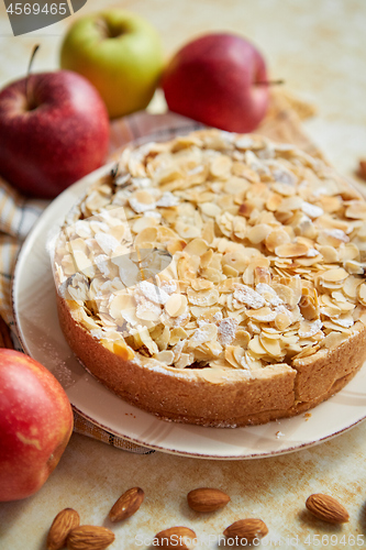 Image of Freshly baked homemade apple pie with almond flakes cake on yellow