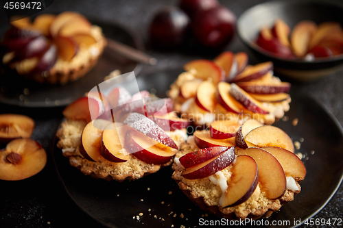 Image of Delicious homemade mini tarts with fresh sliced plum fruit