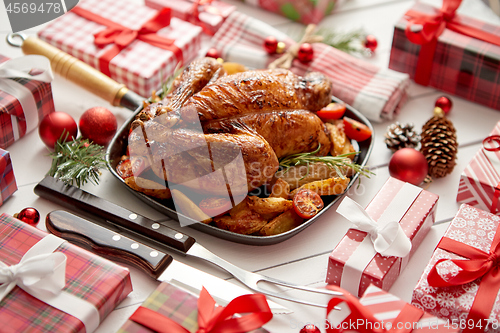 Image of Roasted whole chicken or turkey served in iron pan with Christmas decoration